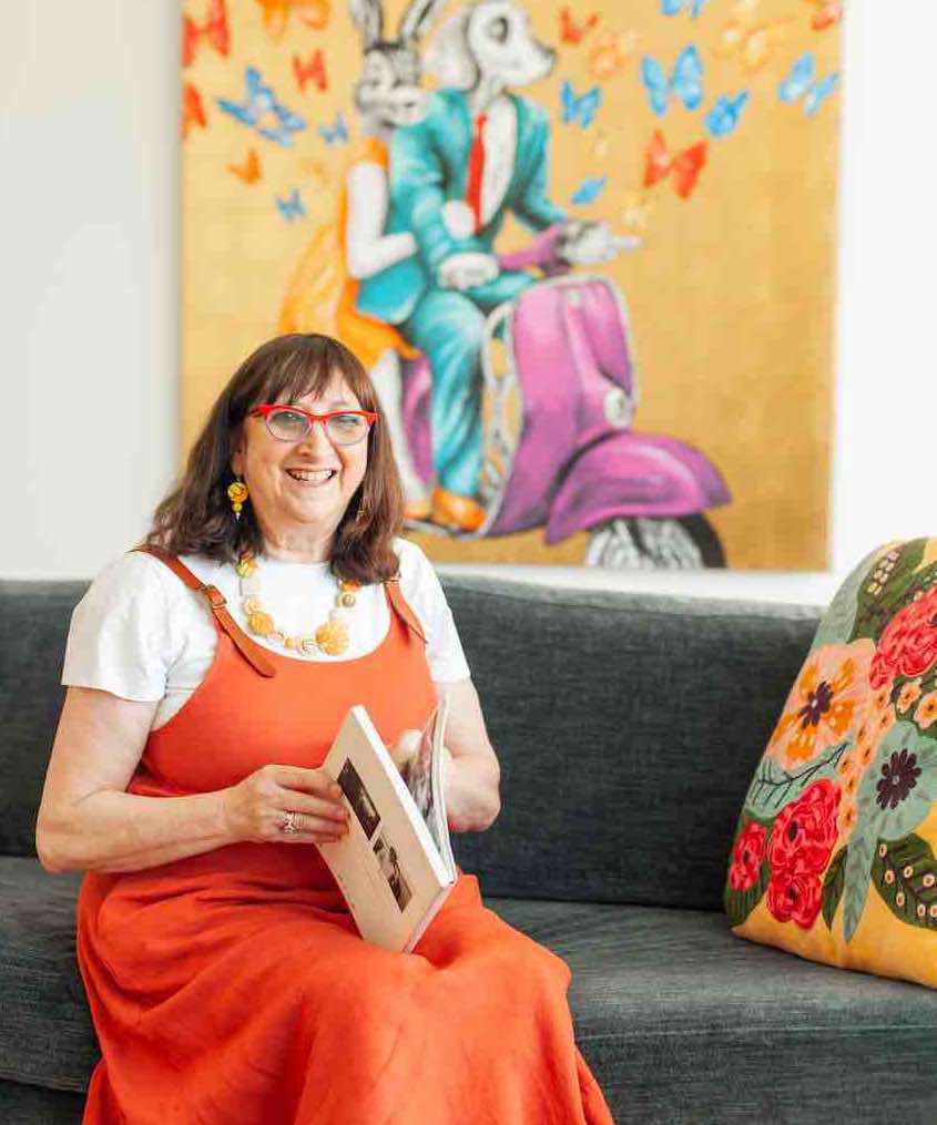 Marica from Design by Culture reading a book on a couch